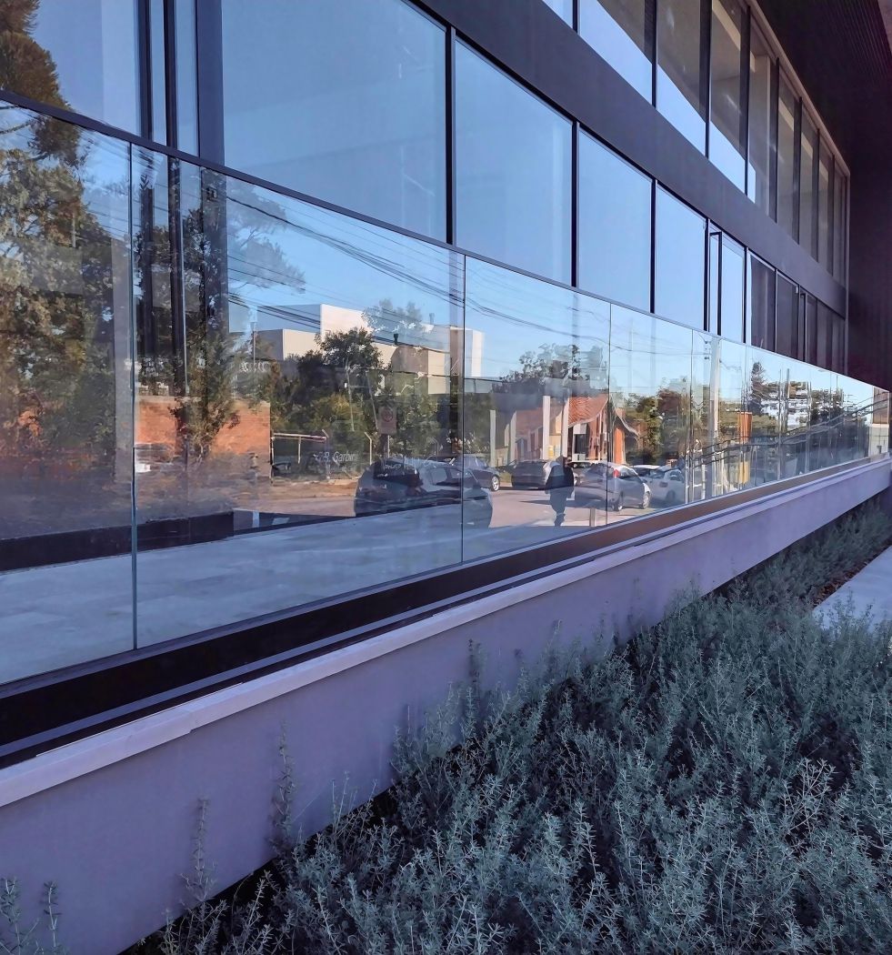 Guarda-corpo Vitrum instalado com capa e perfil na cor preta, em um empreendimento no qual não atrapalha a vista para as vitrines.