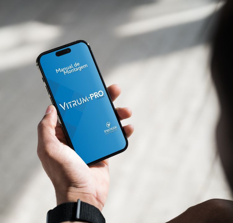 Homem segurando um celular, no qual demostra o manual de montagem do Guarda-corpo Vitrum.